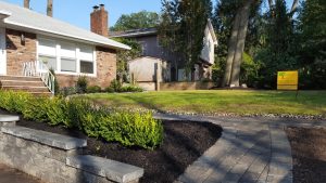 a walk way with a natural stome retaining wall i and garden Tenafly NJ