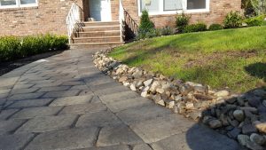 a walk way with a natural stome retaining wall in Tenafly NJ